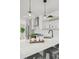 Bright kitchen features quartz counters, stainless appliances, and modern globe pendant lights at 1578 Lowell Blvd # 1, Denver, CO 80204