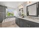 Bathroom featuring dual vanities, framed mirrors, bathtub, and tile surround at 2090 Bellavista St, Castle Rock, CO 80109
