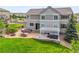 Exterior view of the back of a two-story house with outdoor kitchen, dining area, hot tub, and fire pit at 2090 Bellavista St, Castle Rock, CO 80109