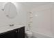 Bathroom features tub/shower combo, sleek black vanity with a white countertop, and a round mirror at 11651 Pennsylvania St, Northglenn, CO 80233