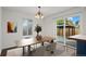 Dining area with modern table and chairs and sliding glass doors leading to a backyard gazebo at 11651 Pennsylvania St, Northglenn, CO 80233