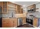 Modern kitchen with stainless steel appliances, wooden cabinets, and open shelving at 11651 Pennsylvania St, Northglenn, CO 80233
