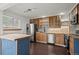 Modern kitchen with island, stainless steel appliances, wood cabinets, and hardwood floors at 11651 Pennsylvania St, Northglenn, CO 80233