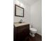 Clean powder room with a dark wood vanity, light countertop, modern faucet and toilet at 11651 Pennsylvania St, Northglenn, CO 80233
