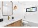 Bright bathroom featuring white tile, brass hardware, a vanity with gold accents, and modern lighting at 516 Grant Ave, Louisville, CO 80027