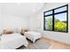 Cozy bedroom with two twin beds, a large window providing natural light, and hardwood floors at 516 Grant Ave, Louisville, CO 80027