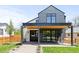 Modern home exterior with a covered front porch featuring a wood ceiling and black support beams at 516 Grant Ave, Louisville, CO 80027