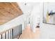 Bright hallway with hardwood floors, modern railing, and natural wood paneled ceiling at 516 Grant Ave, Louisville, CO 80027