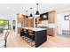 Modern kitchen features a large island with seating, wood cabinetry, stylish pendant lighting, and stainless steel appliances at 516 Grant Ave, Louisville, CO 80027