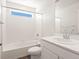 Bright bathroom features a shower-tub combination with white tiled walls at 9089 Pitkin St, Commerce City, CO 80022