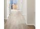 Hallway features light wood floors and white trim leading to a bright, sunlit exit at 9089 Pitkin St, Commerce City, CO 80022