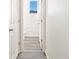 Hallway with luxury vinyl plank flooring leading to a pristine white half bathroom at 9089 Pitkin St, Commerce City, CO 80022