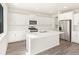 Bright kitchen featuring white cabinets, stainless steel appliances, large island, and stylish backsplash at 9089 Pitkin St, Commerce City, CO 80022