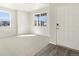 Open living area featuring carpet, large windows providing natural light and neutral paint at 9089 Pitkin St, Commerce City, CO 80022