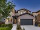 Charming two-story home with a stone facade, gray siding, and a basketball hoop on the driveway at 10968 Pastel Pt, Parker, CO 80134