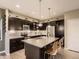 Stylish kitchen with dark cabinets, quartz countertops, stainless steel appliances, and a center island with seating at 10968 Pastel Pt, Parker, CO 80134