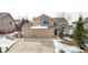 Charming two-story home featuring a three-car garage, stone accents, and a well-maintained front yard with wintery landscaping at 477 Saber Creek Dr, Monument, CO 80132