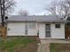 Home's rear exterior showcasing a patio, fenced yard, and access to the house at 4990 Hooker St, Denver, CO 80221