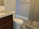 A bathroom with a granite countertop, toilet, and tiled shower with a glass door at 4990 Hooker St, Denver, CO 80221