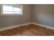 A bedroom with gray walls, white trim, wood floors, and a window with blinds at 4990 Hooker St, Denver, CO 80221