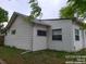 White house with windows and a nice yard surrounded by trees at 4990 Hooker St, Denver, CO 80221