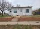 Charming single-story home featuring a well-manicured lawn and a welcoming front porch at 4990 Hooker St, Denver, CO 80221
