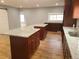 A kitchen with a brown wood cabinets, stainless steel sink, white granite countertop, and wood floors at 4990 Hooker St, Denver, CO 80221