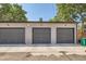 Three-car garage exterior with modern gray doors and a sidewalk at 2846 Champa St, Denver, CO 80205