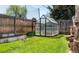 Backyard greenhouse featuring metal frame and a tranquil garden space for cultivating plants and vegetables at 2548 S Zurich Ct, Denver, CO 80219