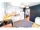 Modern kitchen featuring white cabinets, stainless steel appliances, black and white checkered floor, and contrasting dark blue walls at 2548 S Zurich Ct, Denver, CO 80219