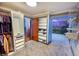 Functional walk-in closet design featuring organized storage and a view to a room with unique mountain mural at 2548 S Zurich Ct, Denver, CO 80219