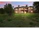 Spacious backyard with lush lawn and a brick home featuring a deck perfect for outdoor entertaining and relaxation at 4212 E Orchard Pl, Centennial, CO 80121