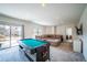 Spacious basement features a comfortable seating area, pool table, and access to outdoor space at 4212 E Orchard Pl, Centennial, CO 80121