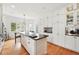 Bright kitchen features custom white cabinets, stainless steel appliances, and an eat-in island with bar stool seating at 4212 E Orchard Pl, Centennial, CO 80121