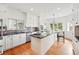 Bright kitchen features custom white cabinets, stainless steel appliances, and an eat-in island with bar stool seating at 4212 E Orchard Pl, Centennial, CO 80121
