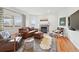 Cozy living room with a fireplace, leather seating, and large windows providing natural light and comfort at 4212 E Orchard Pl, Centennial, CO 80121