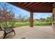 Relaxing covered patio featuring brick column, lush lawn, and views to a green space at 4212 E Orchard Pl, Centennial, CO 80121
