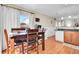 Bright dining area with a dark wood table, adjacent to a kitchen and access to backyard at 200 Vista Blvd, Brighton, CO 80603