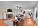 Comfortable living room with a brick fireplace, TV, ceiling fan, and hardwood floors at 200 Vista Blvd, Brighton, CO 80603