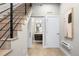 Hallway with stairs leading to a half bath and laundry closet, offering convenience and style at 4469 Tennyson St # 15, Denver, CO 80212