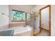 Bright bathroom featuring a soaking tub with tile surround and a glass enclosed shower at 13673 Cook St, Thornton, CO 80602