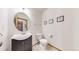 Chic powder room with a modern vanity, round mirror, and decorative wall art at 13673 Cook St, Thornton, CO 80602