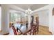 Elegant dining area with hardwood floors, stylish chandelier, and large windows offering natural light at 13673 Cook St, Thornton, CO 80602