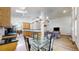 Open-concept kitchen with black countertops, stainless steel appliances, and hardwood floors, creating a modern and functional space at 13673 Cook St, Thornton, CO 80602