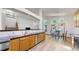 Bright, open kitchen features wood cabinets, stainless steel appliances, and dining area with backyard views at 13673 Cook St, Thornton, CO 80602