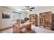 Bright home office with a large desk, two bookshelves, and a large window at 13673 Cook St, Thornton, CO 80602