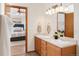 En-suite bathroom with double sinks and a view into the bright and cozy bedroom at 205 Hawthorn St, Frederick, CO 80530