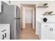 Bright kitchen with stainless steel refrigerator and view down hall to front door at 205 Hawthorn St, Frederick, CO 80530