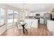 Eat-in kitchen with bright white cabinets, stainless appliances, and sliding glass door to the back yard at 205 Hawthorn St, Frederick, CO 80530