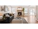 Bright living room with hardwood flooring, a cozy fireplace, and picture windows at 205 Hawthorn St, Frederick, CO 80530